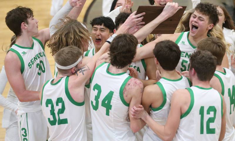Members of the Seneca boys basketball team celebrate after winning the Tri-County Conference championship over Marquette on Friday, Jan. 31, 2025 at Putnam County High School.
