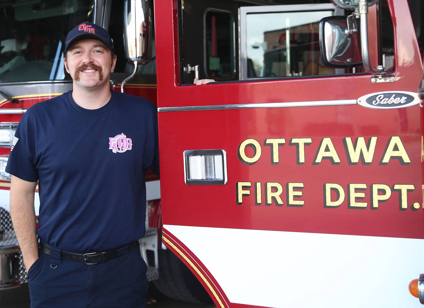 Veteran Brian Ksaizak poses for a photo next to a fire engine on Monday, Oct. 6, 2025 at the Ottawa Fire Station.
