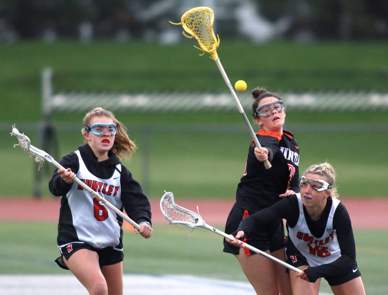 Huntley’s Leah Holmberg, left, and Katie Ferrara, right, battle Crystal Lake Central’s Colleen Dunlea in varsity lacrosse at Huntley Wednesday.