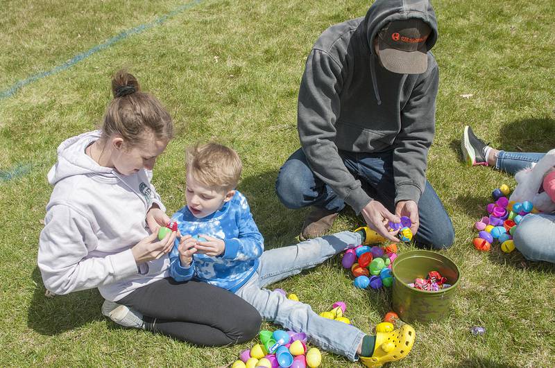 Alyssa Abbott, son River Gunnon, 5, and Tyler Abbott crack open their eggs to gather up the sweet candy inside.