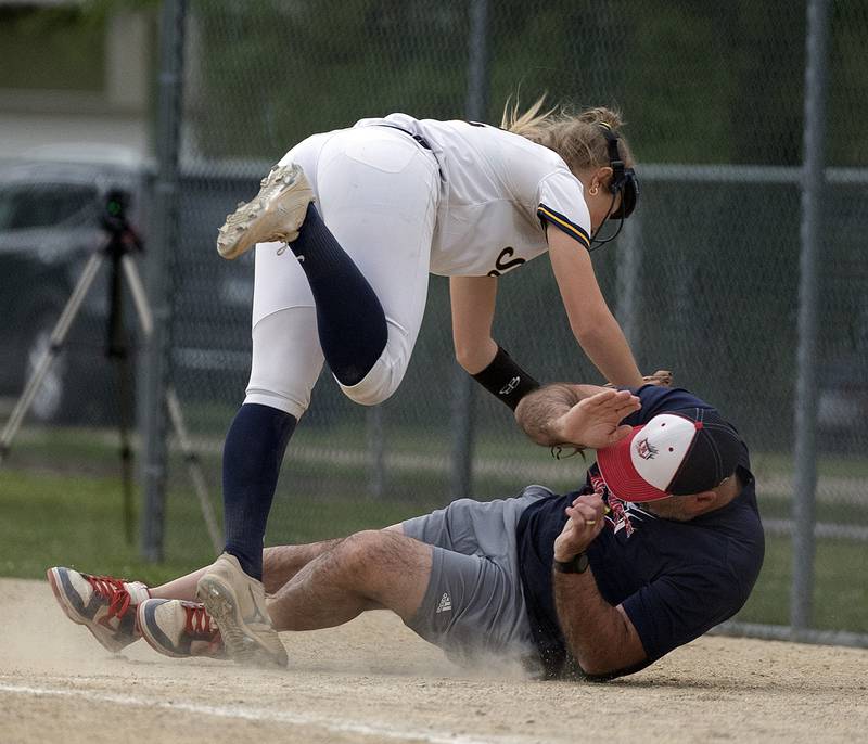 Sterling’s Georgia Gallardo crashes into the Belvidere North first base coach while chasing a foul ball Friday, May 30, 2025, in the Class 3A Regional final in Dixon. The batter was called out on the play.