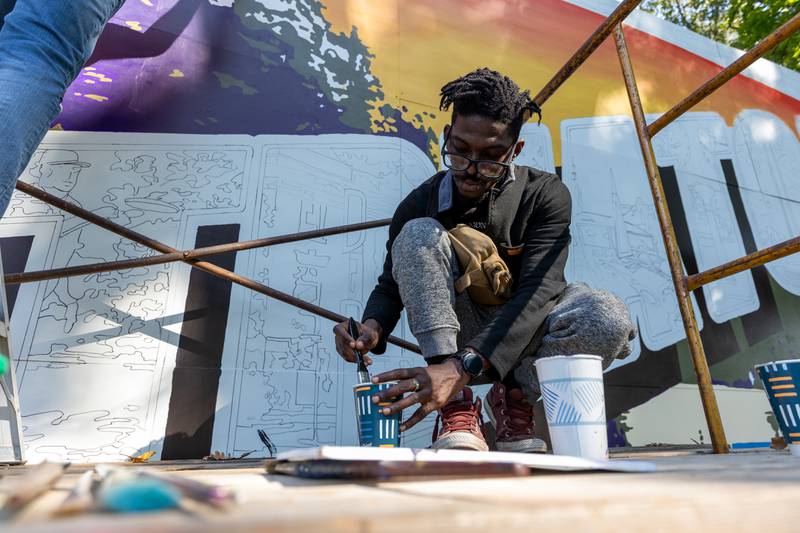 Nate Petit-Dieu of the Walldogs washes brush whilst crouching on top of scaffolding on Thursday, Sept. 11, 2025 at City Park in Streator.