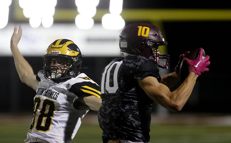 Richmond-Burton's Max Loveall catches a pass in front of Harvard's Bernard Bahnsen during a Kishwaukee River Conference football game on Thursday, Oct.12, 2023, at Richmond-Burton High School.