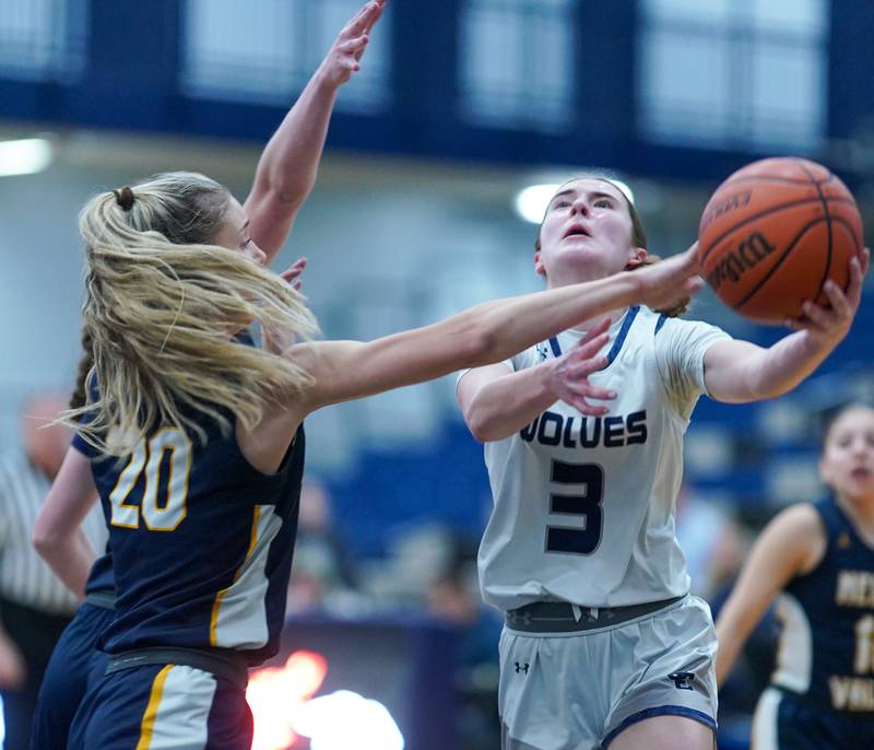 Oswego East's Maggie Lewandowski (3) drives to the basket against Neuqua Valley's Kylee Norkus (20) during a basketball game at Oswego East High School in Oswego on Saturday, Jan 6, 2024.