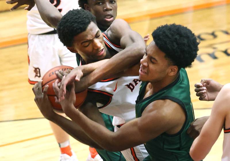 DeKalb’s Justin O’Neal tries to grab a rebound between Waubonsie Valley's Tyreek Coleman (left) and Tyler Threat during their game Friday, Dec. 15, 2023, at DeKalb High School.