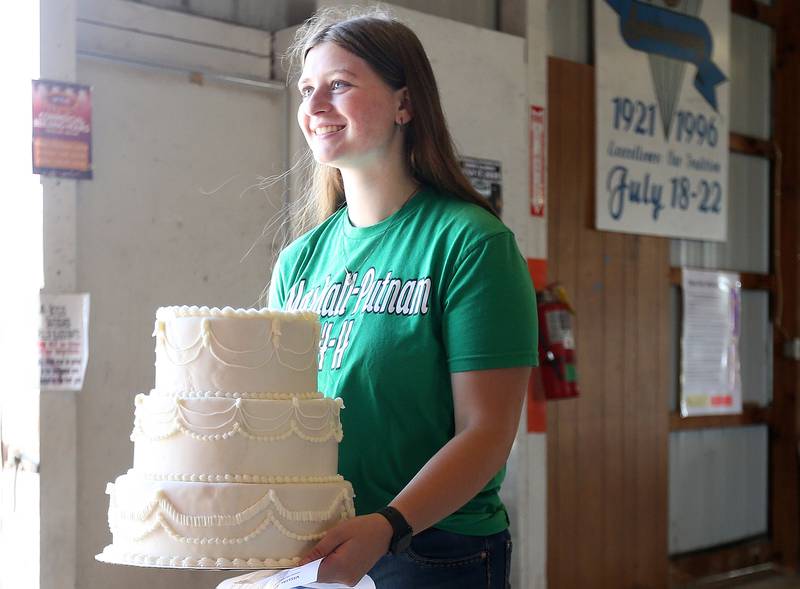 Cadence Breckenridge of Lostant, holds her cake that she made during the Marshall-Putnam County 4-H Fair on Wednesday, July 23, 2025 at the Marshall-Putnam Fairgounds in Henry.