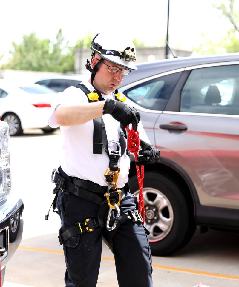 Mike Benz, Geneva Fire Department special teams coordinator and battalion chief, ties a knot for a rappelling training exercise at the Third Street Commuter Parking Deck on Tuesday, May 13, 2025 in Geneva.