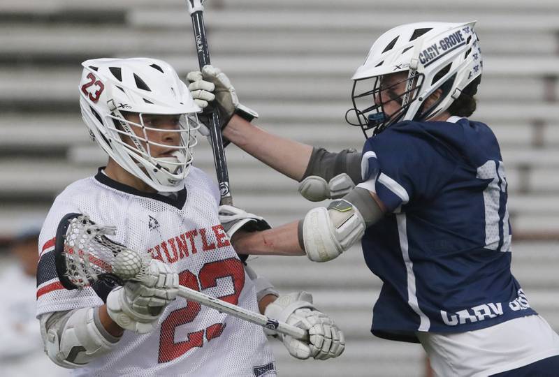Huntley's Dominic Scarpelli is guarded by Cary-Grove's Jack Lamb during the Marian Central Sectional boys lacrosse semifinal match on Wednesday, May 28, 2025, at Marian Central High School in Woodstock.