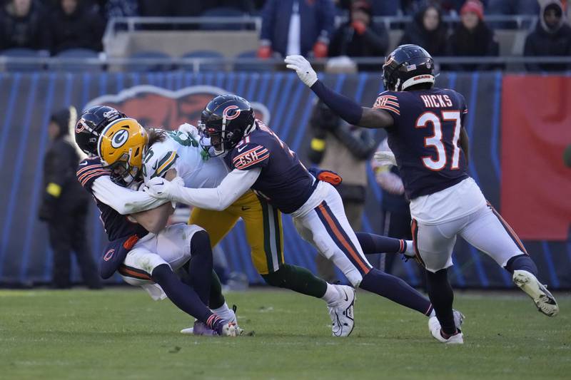 Green Bay Packers tight end Robert Tonyan is tackled by Chicago Bears defensive backs Josh Blackwell (left) and Jaylon Jones during the second half, Sunday, Dec. 4, 2022, in Chicago.
