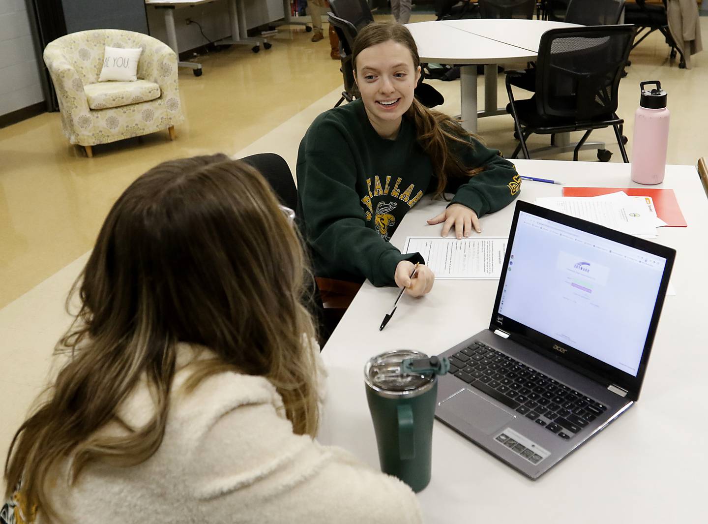 Hailey Baker, the college and career advisor at Crystal Lake South High School, helps senior Meg Norten fill out a scholarship application Thursday, Jan. 26, 2023, at the school in Crystal Lake. This year's senior class is made up of students who began their high school careers dealing with COVID-19.