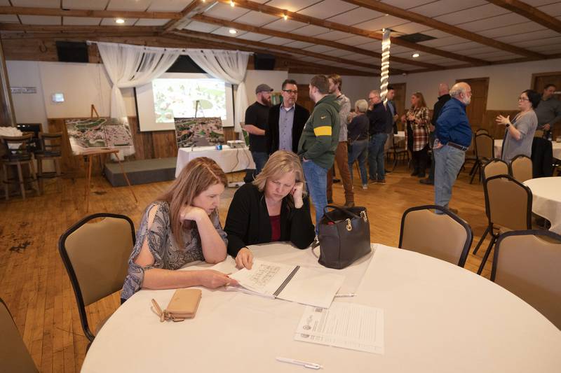 Dr. Tami Stringer (left) and Jennifer Rylander look over  schematics of the some of the buildings Wednesday, April 5, 2023 during the Riverfront Commission’s redevelopment plan event. Stringer’s office is downtown so she’s especially interested in the plan.