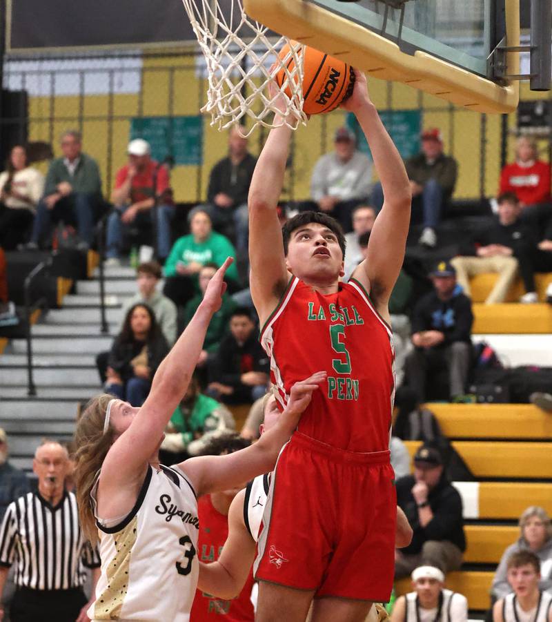 La Salle-Peru's Erick Sotello scores in front of Sycamore's Carter McCormick during their game Tuesday, Feb. 4, 2025, at Sycamore High School.