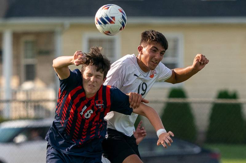 Oswego’s Nolan Gustafson (18) heads the ball against Wheaton Warrenville South's Nikhil Bawa (19) during a soccer match at Oswego High School on Thursday, Aug 25, 2022.