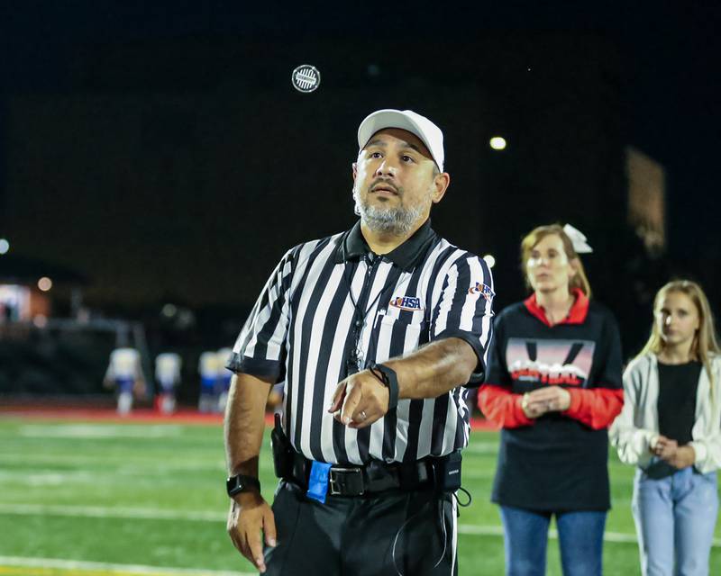 The referee performs the pregame coin flip before Lincoln Way West's game versus Sandburg.  Sept 22, 2023.