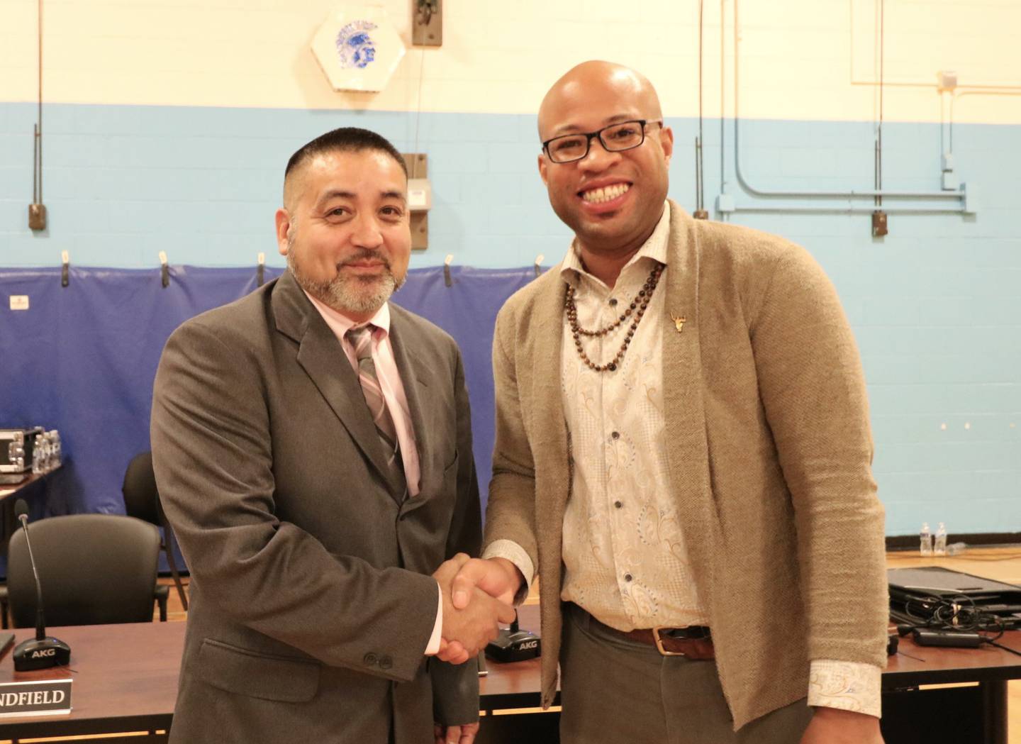 Jesse Smith (left) is welcomed to the Joliet Public Schools District 86 Board of School Inspectors by its president, Erick Deshaun Dorris