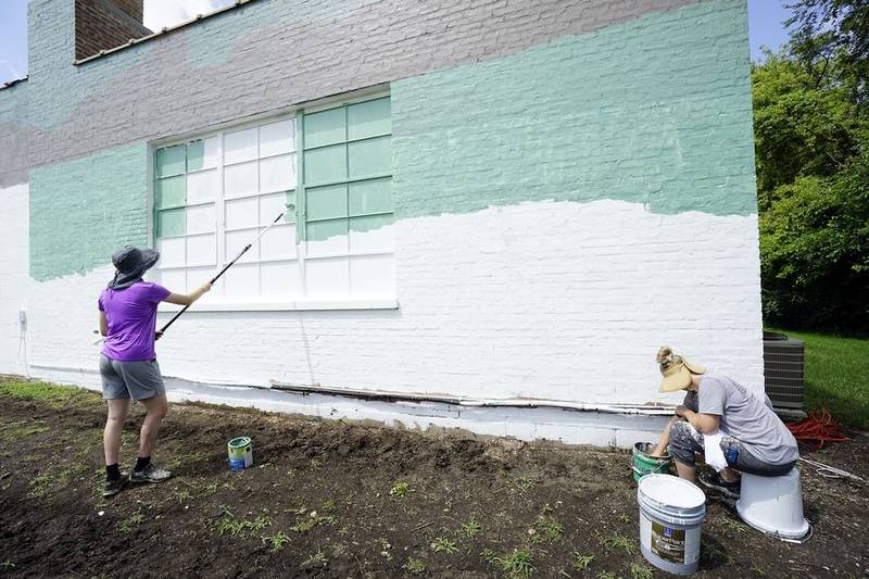 Maddie Deiters and her mom Deanna (seated) work on the background colors for the first piece of public art commissioned by the East Dundee Arts Council. The mural should be completed by Wednesday.