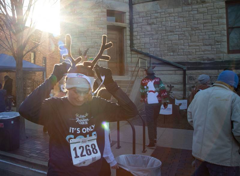 Kristi Kunkel of Glen Ellen puts her medal on after finishing the 13th annual Lions Charities Reindeer Run 5K Wheaton on Saturday, Dec. 7, 2024.