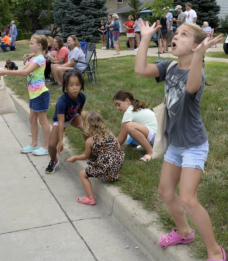 Claire Popplewell looks to the skies Sunday, Aug. 14, 2022, as candy treats are tossed to children along Walnut Street during the Wenona Days parade.