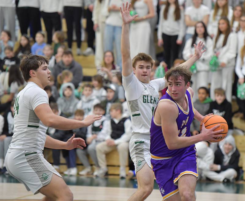 Downers Grove North’s Jacob Vroman (right) drives to the basket as Glenbard West’s Brady Johnson (left) and Finn Sheeley defend during a game on January 23, 2026 at Glenbard West High School in Glen Ellyn.