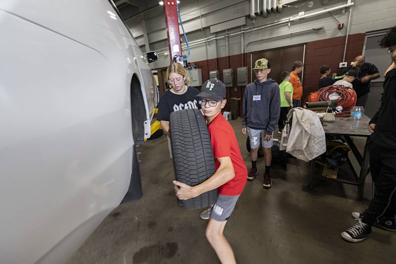 Cannon Sands, 12, of Rock Falls removes a tire during the automotive trade camp session at WACC Thursday, July 13, 2023. Campers spent two days at four different sessions over the course of eight days.