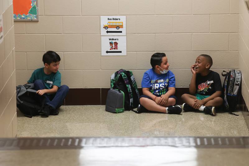 Students sit in the hall waiting to go into class on the first day of school at Woodland Elementary School in Joliet. Wednesday, Aug. 17, 2022, in Joliet.