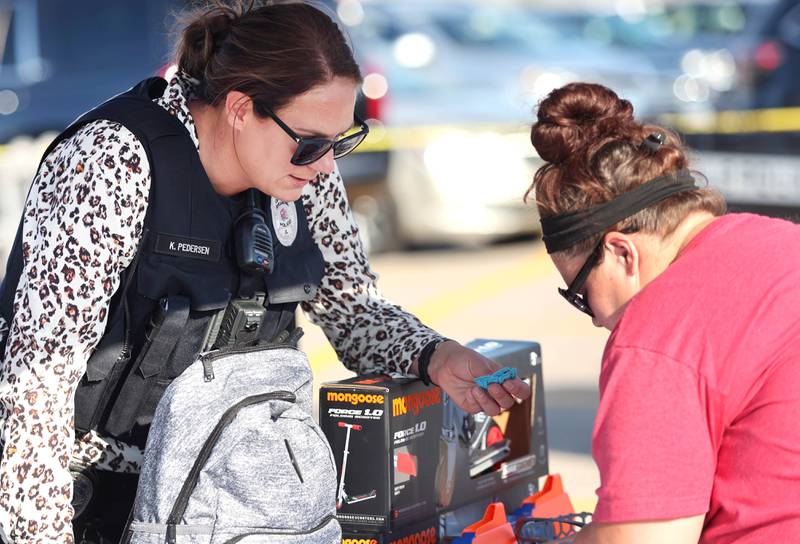 Sycamore Police Officer Kaitlyn Pedersen hands out raffle tickets Tuesday, Aug. 2, 2022, during National Night Out in the parking lot of the Walmart on Sycamore Road in DeKalb.