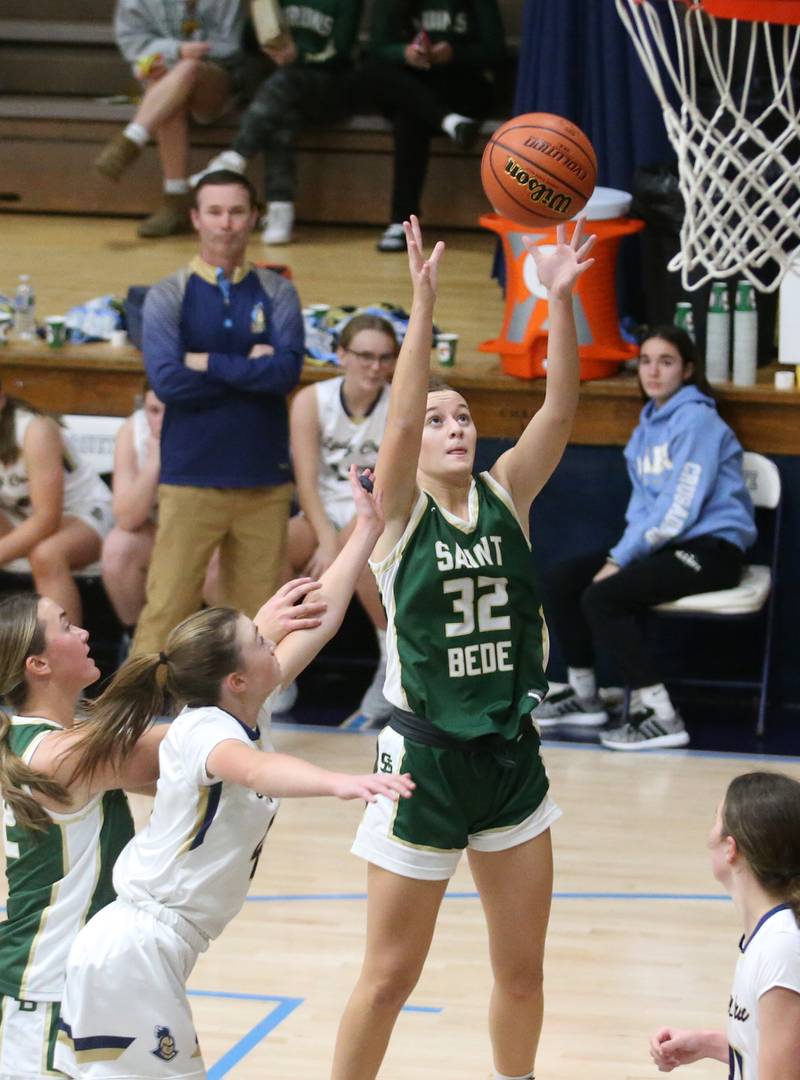 St. Bede's Quinn McClain takes a shot in the lane over Marquette's Chloe Larson on Monday, Nov. 27, 2023 in Bader Gym at Marquette High School.