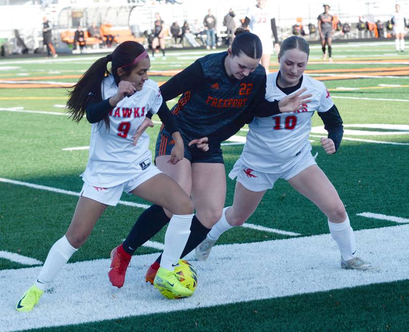 Oregon's Bezzali Cadenas (9) and Shaylee Davis (10) squeeze Freeport's Kennadee Lind (22) for the ball during a Monday, March 31, 2025 game at Freeport High School. The Hawks lost the game 3-1.