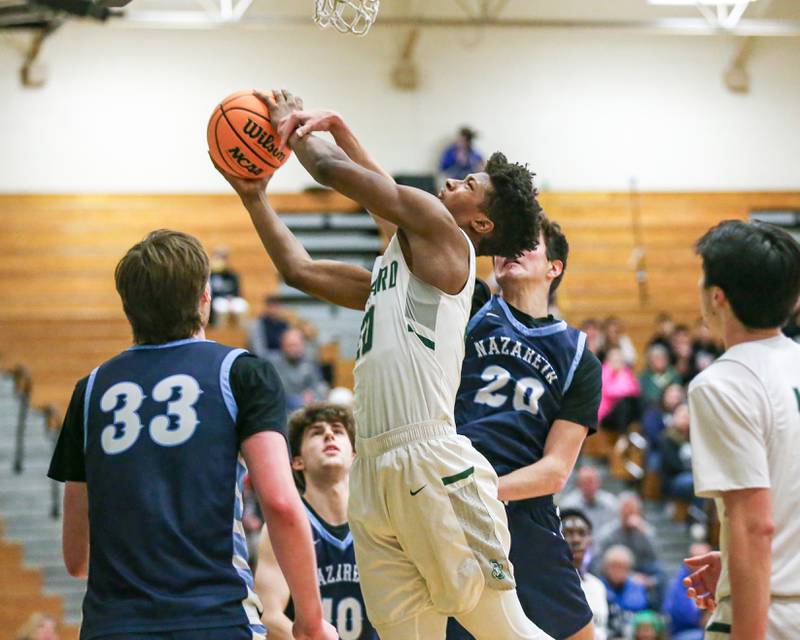 Glenbard West's Logan Glover (20) is fouled at the basket during their Jack Tosh Holiday Classic basketball tournament game between Nazareth vs Glenbard West. Thursday Dec 26, 2024 in Elmhurst.