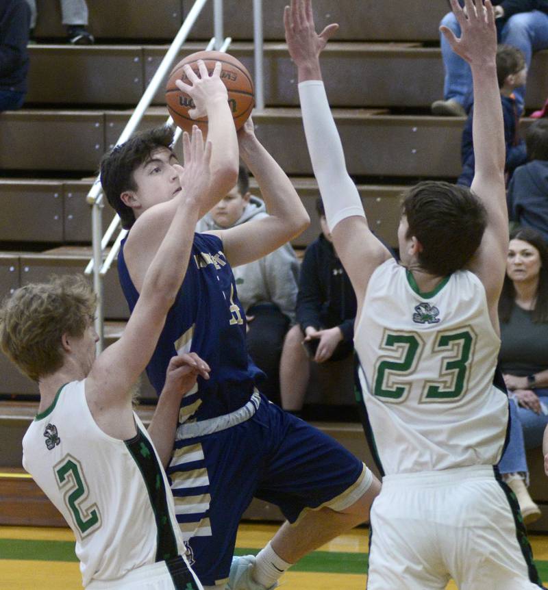 Marquette’s Carson Zellers gets a shot over Seneca’s Kenny Daggett and Brady Sheedy Tuesday during the 1st period at Seneca.