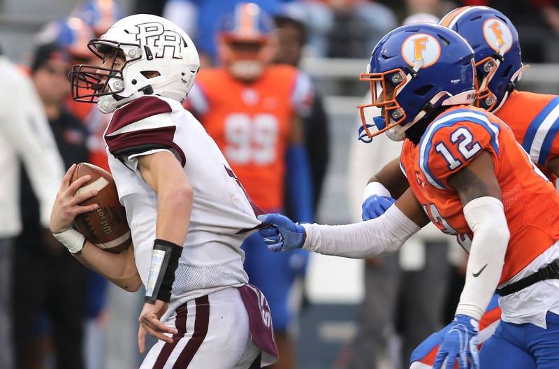 Prairie Ridge's Tyler Vasey tries to pull away from East St. Louis' Michael Tillman during their IHSA Class 6A state championship game Saturday, Nov. 26, 2022, in Memorial Stadium at the University of Illinois in Champaign.