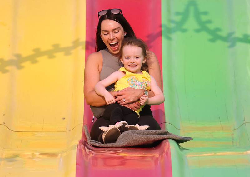Mary Mangieri rides the slide with her niece Addyson Memenga, 3, at Genoa Days, Wednesday, June 7, 2023, in downtown Genoa. The festival continues through Saturday.