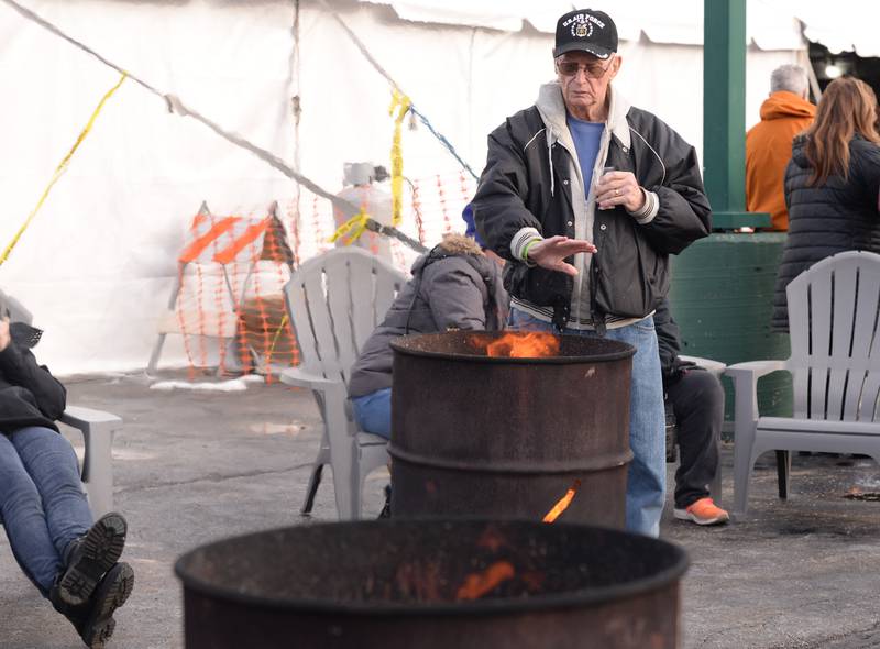 Ray Harden of Westmont warms up near the fire during the Westmont Winter Beer Festival Saturday Feb 18, 2023.