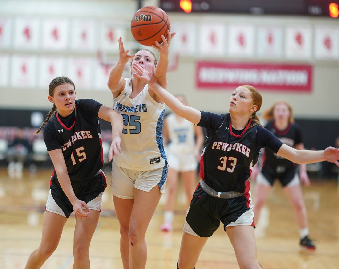 Nazareth guard Amalia Dray (25) rebounds the ball against Pewaukee (WI) guard Kylie Pieper (15) and guard Kennedy Retherford (33) during the 34th annual Coach Kipp’s Hoops Fest at Benet Academy in Lisle on Monday, Jan 15, 2024.