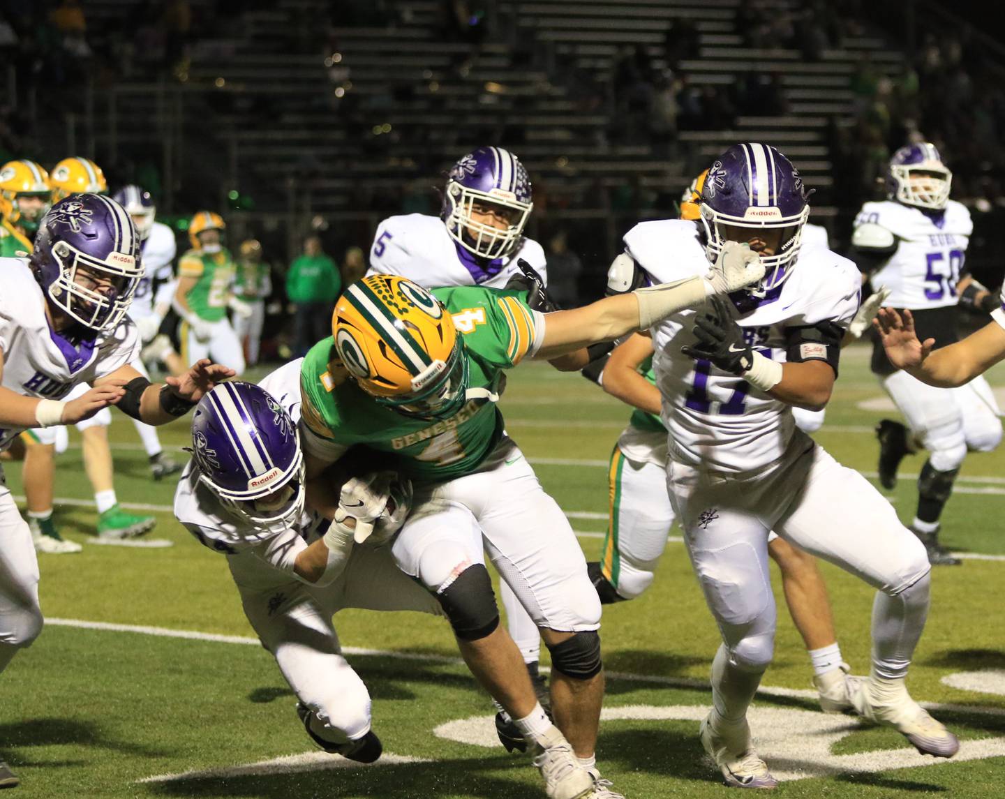 Rochelle's Keagan Albers (left) makes a tackle while a Geneseo player grabs the facemask of Rochelle's Reece Harris during Friday's game at Geneseo.