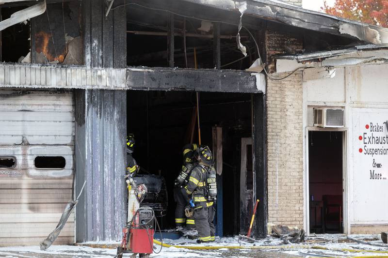After dousing the fire with foam, firefighters look to check the ceiling for hot spots Friday, Nov. 7, 2025, in Sterling.