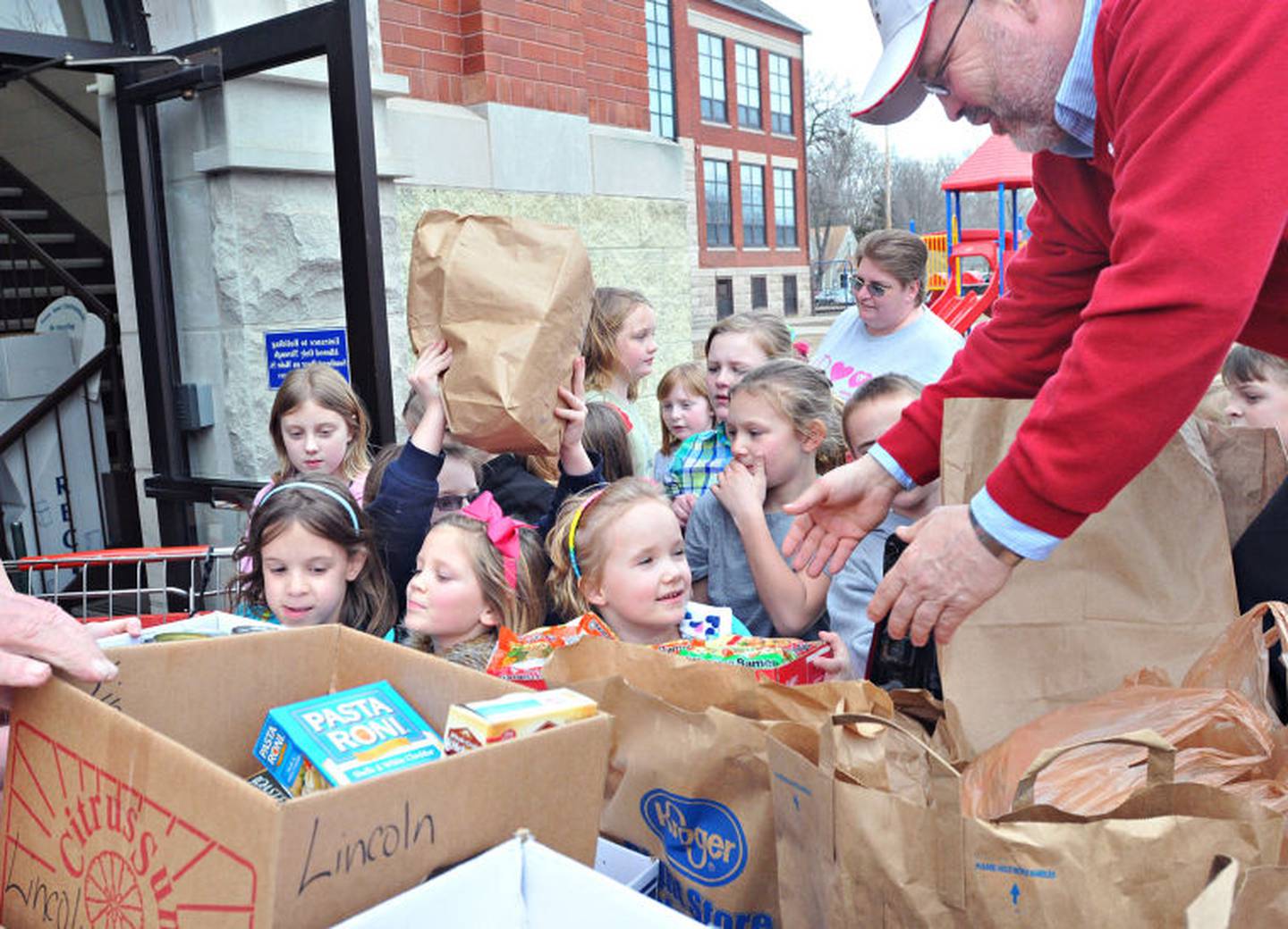 Lincoln Elementary School students hand David Raikes, Laborers Local 393 business manager, food collected by the school’s Neediest Kids Committee in 2012. The food was delivered to the victims of a tornado in Harrisburg.