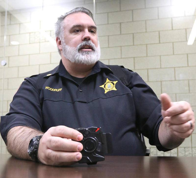 DeKalb Police Commander, Craig Woodruff talks Thursday at the department, about the body camera he is holding and some of the ways the department would use the new technology. The department was approved for pilot a body camera program in the fiscal year 2020 city budget.