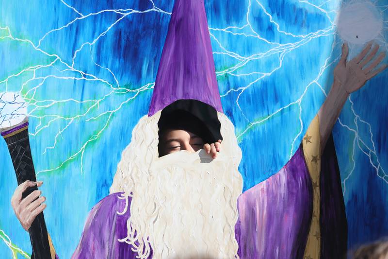 Sky Salinas, 8, from Romeoville peaks through the wizard cutout at the Magic in Morris event on Saturday.