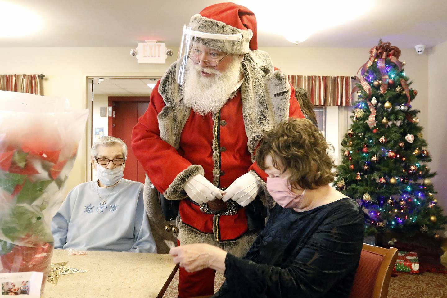 Santa Claus visits with residents during an adopt-a-grandparent gift event at Gable Point Senior Housing on Wednesday, Dec. 22, 2021, in Crystal Lake.