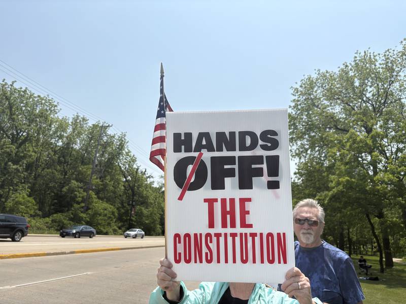 Nancy Kneip holds up a sign during a rally against President Donald Trump in Huntley May 31, 2025.