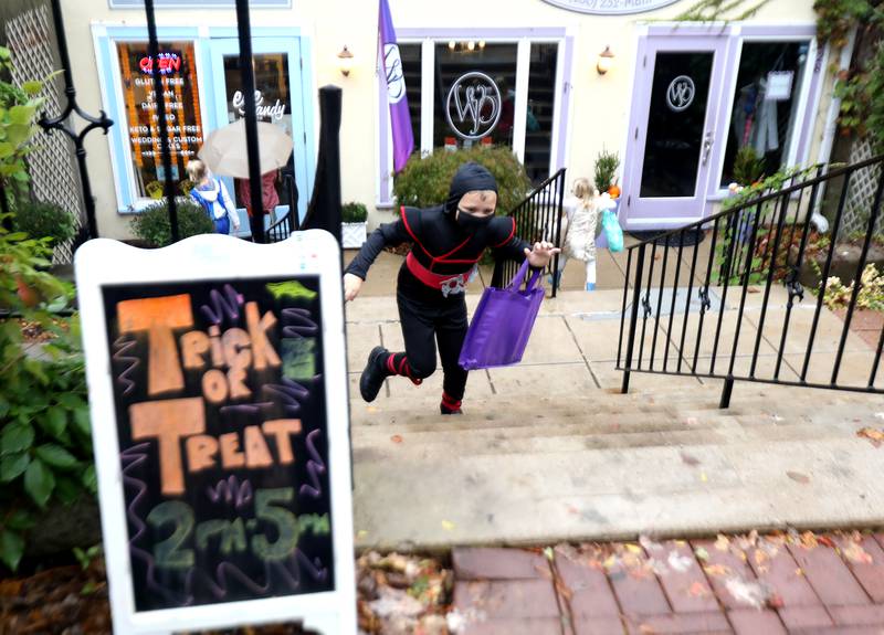 Dylan Hardersen, 6, dressed as a ninja, heads up some stairs during the annual trick-or-treating at downtown Geneva businesses on Thursday, Oct. 28, 2021.