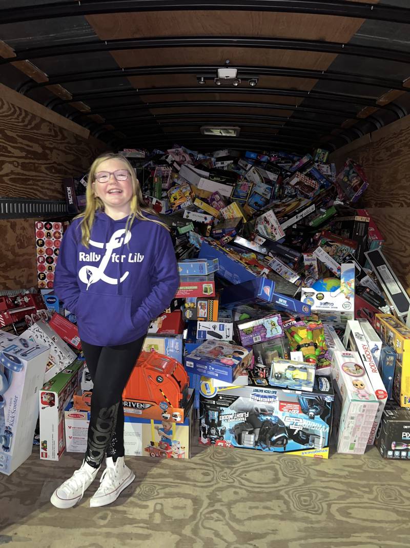 Mya Rospoch, 11, stands by a truckload of toys collected for Lily's Toys for Joy toy drive to be given to the patients at the Children's Hospital of Illinois in Peoria.