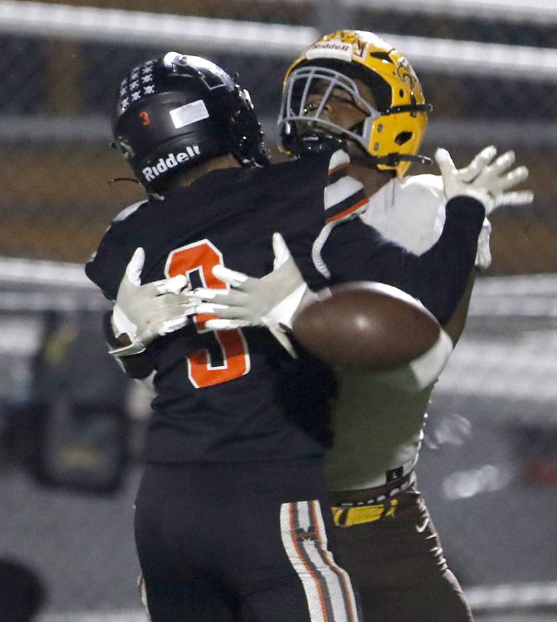 Jacobs' PJ Barnes tries to catch the football as he is hit by McHenry's Rogelio Rios during a Fox Valley Conference football game on Friday, Oct. 18, 2024, at McCracken Field in McHenry.