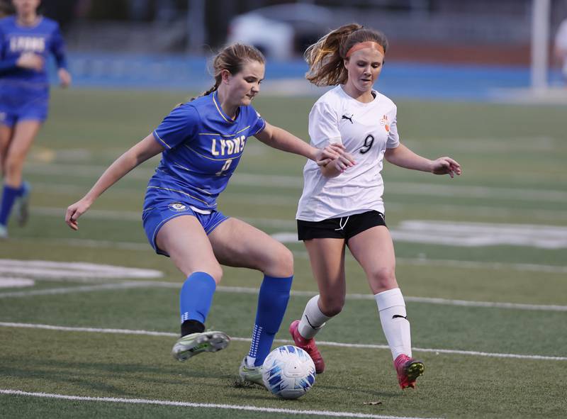 Wheaton Warrenville South's Kelsey Clousing (9) fights for the ball against Lyons Township's Claire Mortonson (9) during the girl's varsity soccer match between Lyons Township and Wheaton Warrenville South high schools on Thursday, March 27, 2025 in Western Springs.