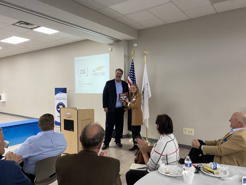 Adam Hess presents Nancy Norton with an award thinking her for her work in helping CSX establish the Clarius Business Park in Grundy County, and collaborating with CSX to make sure it would be successful.