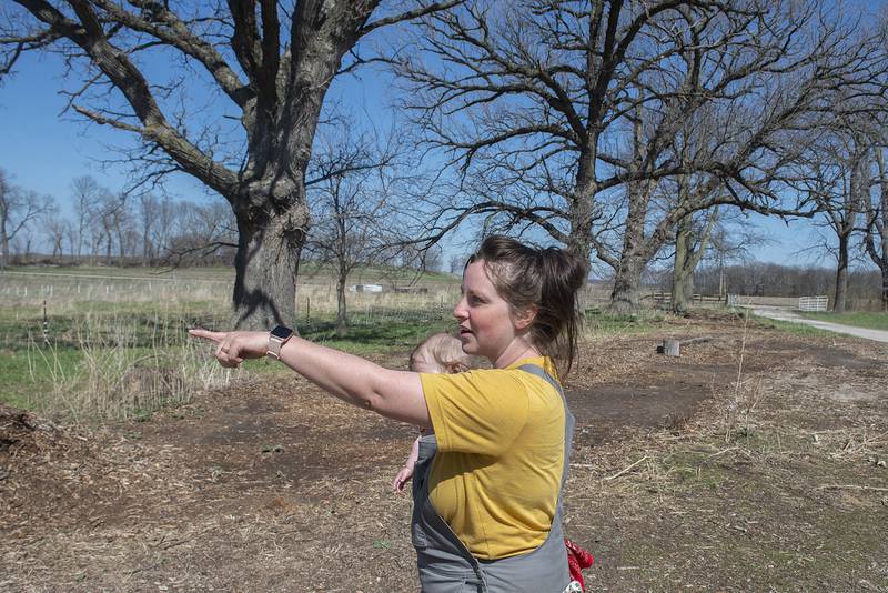 Olson gestures towards the garden while taking a look around Thursday, April 21, 2022. It’s still early in the season but the farm will grow fruits and vegetables like apples, radish, onions, and peas.