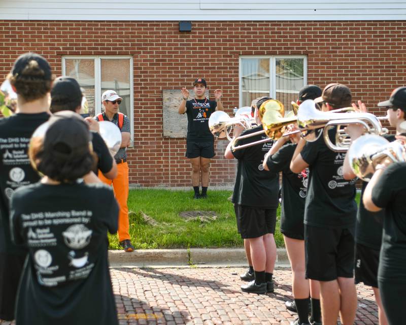 DeKalb High School drum major Ivan Castillo worms up the band while band director Steve Lundin listens before the Memorial parade in DeKalb on Monday May 30th.