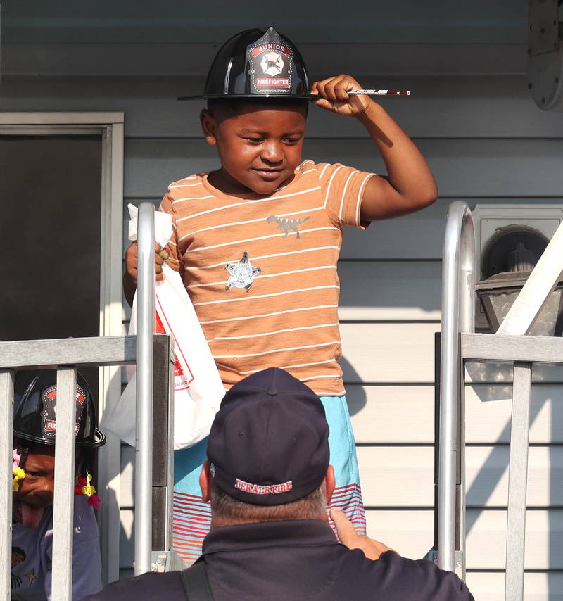 Kobe Lawrence, 4, from DeKalb, adjusts his helmet Tuesday, Aug. 5, 2025, after coming out of the DeKalb Fire Department smoke house during National Night Out in the Hy-Vee parking lot in Sycamore.