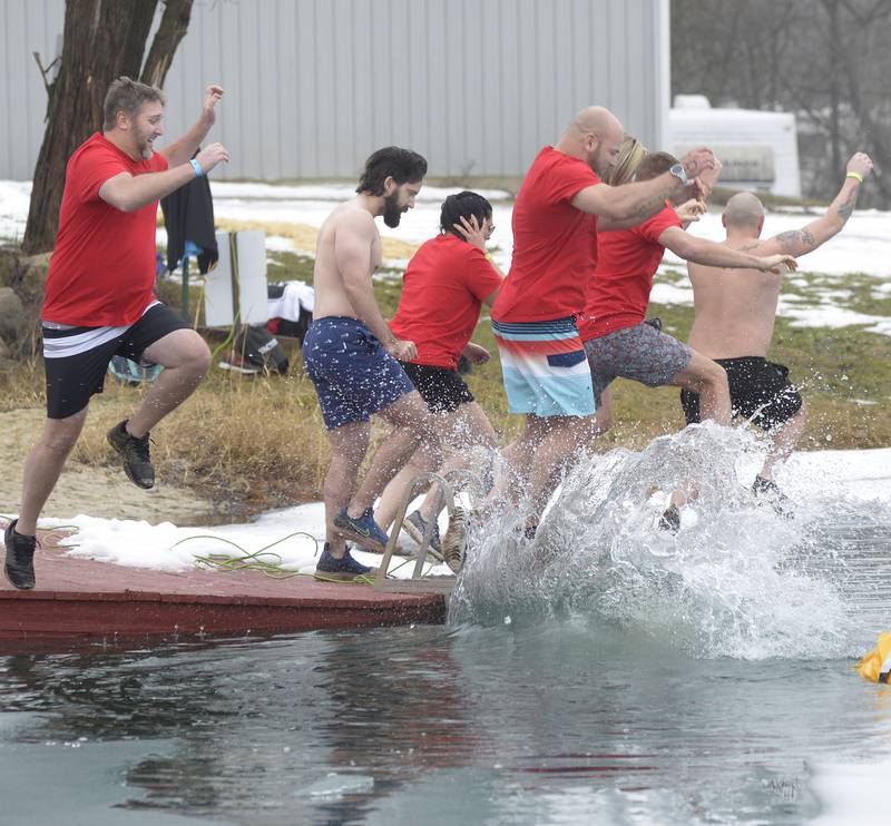 The Vactor team braves the frigid waters Saturday, Jan. 27, 2024, as the first to take the plunge into the icy waters at the swimming pond at Skydive Chicago in Ottawa during the annual Penguin Plunge. The event raised money for the Make-A-Wish Foundation.